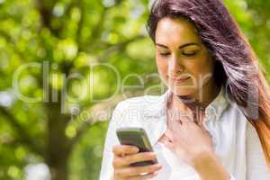 Beautiful brunette in the park sending text
