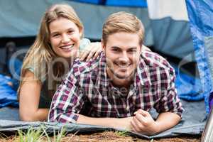 Portrait of a young happy couple lying in a tent