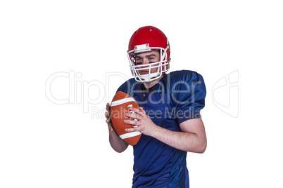 Serious american football player holding a ball