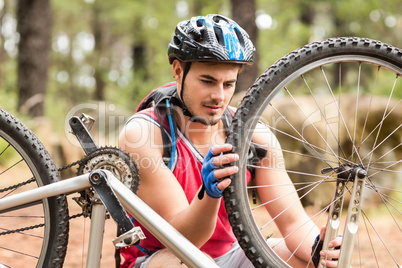 Happy handsome biker repairing bike