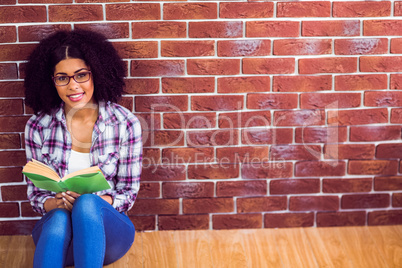 Attractive hipster sitting and reading book