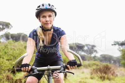 Focused athletic blonde mountain biking