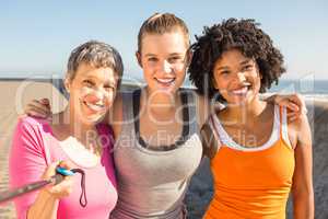 Smiling sporty women taking selfies with selfiestick