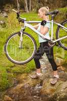 Serious fit woman lifting her bike