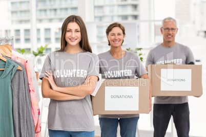 Smiling volunteers holding donation boxes