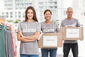 Smiling volunteers holding donation boxes