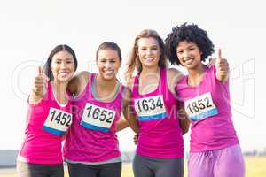 Four smiling runners supporting breast cancer marathon