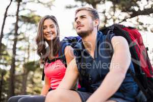 Young happy joggers sitting on rock and looking at camera