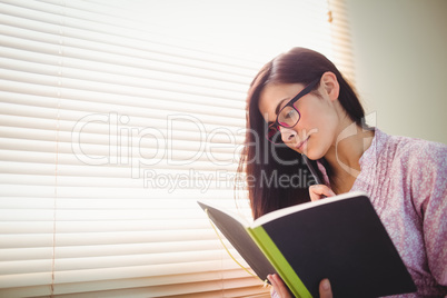 Pretty brunette studying beside window