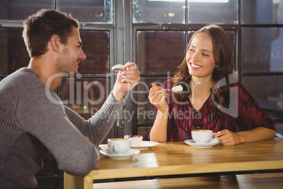 Smiling friends enjoying coffee and cake together