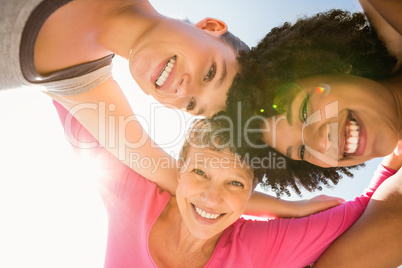 Sporty women with arms around smiling down to camera