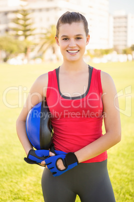 Smiling sporty blonde holding helmet