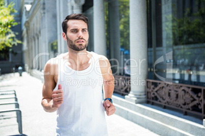 Determined handsome athlete jogging