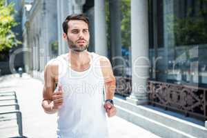 Determined handsome athlete jogging