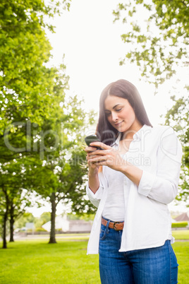 Beautiful brunette sending a text message