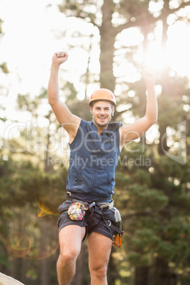 Handsome young hiker looking at camera and cheering