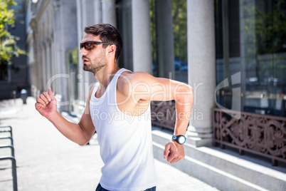 Handsome athlete with sunglasses jogging