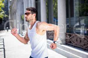 Handsome athlete with sunglasses jogging