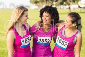 Three laughing runners supporting breast cancer marathon