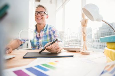 Smiling casual designer using computer and digitizer