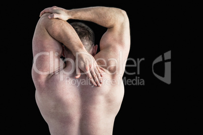 Strong bodybuilder stretching his arm