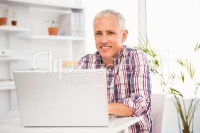 Smiling casual businessman working with computer