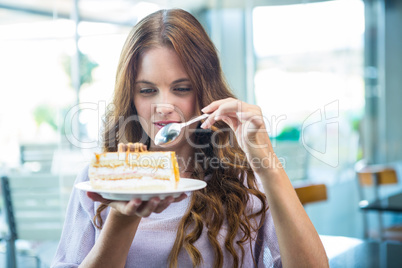 Pretty brunette enjoying a cake