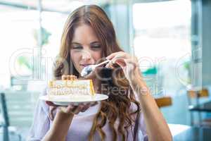 Pretty brunette enjoying a cake