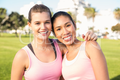 Two smiling women wearing pink for breast cancer