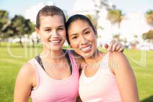 Two smiling women wearing pink for breast cancer