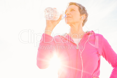 Sporty woman with headphones drinking water