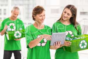 Eco-minded women with tablet and recycling box
