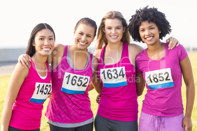 Four smiling runners supporting breast cancer marathon