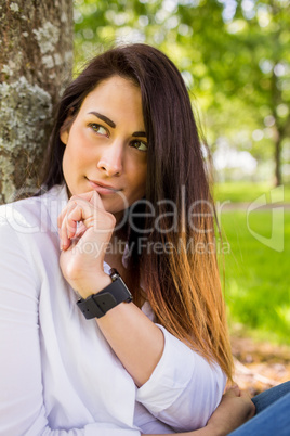 Beautiful brunette thinking in the park