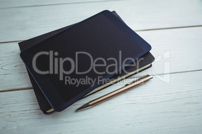 View of a book and tablet lying on desk