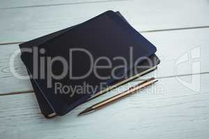 View of a book and tablet lying on desk