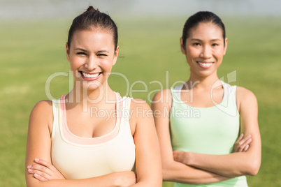 Smiling sporty women with arms crossed