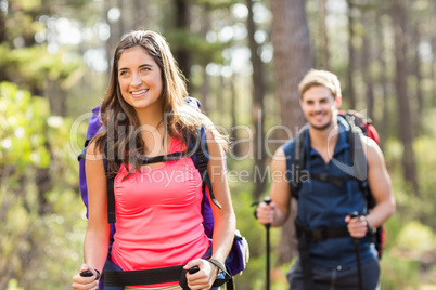 Young happy joggers hiking with trekking poles
