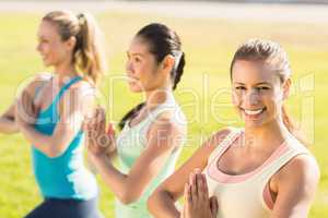 Smiling sporty women doing yoga together