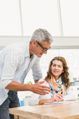 Casual designer briefing his colleague