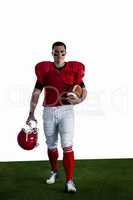 Portrait of american football player walking and holding footbal