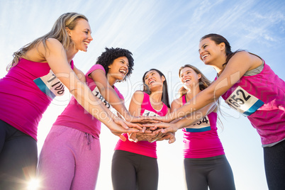 Five smiling runners supporting breast cancer marathon