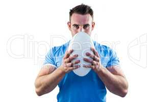 Rugby player looking at camera with ball