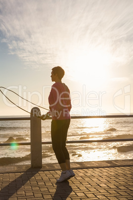 Sporty woman skipping at promenade