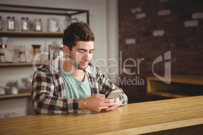 Smiling hipster sitting and texting