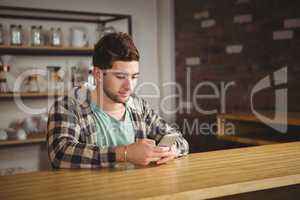 Smiling hipster sitting and texting