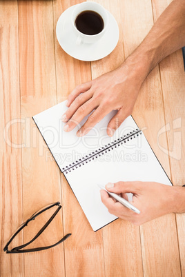 Hands writing on notepad