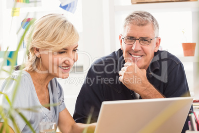 Smiling business team working on laptop