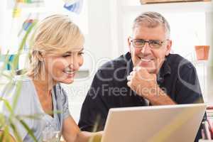 Smiling business team working on laptop