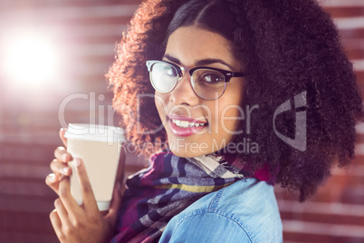 Smiling attractive hipster holding take-away cup